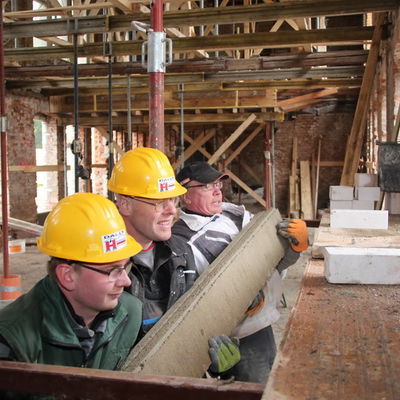 Bild vergrößern: Felix Stiegmüller, Lutz Morgenstern und Jens Roth (von links) von Dally Bau GmbH Bergen bereiten die Südhalle für den Umbau zur Kita vor.