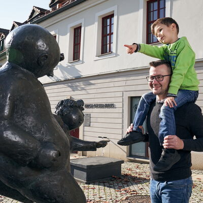 Bild vergrößern: Vater und Sohn vor dem Erich-Ohser-Haus