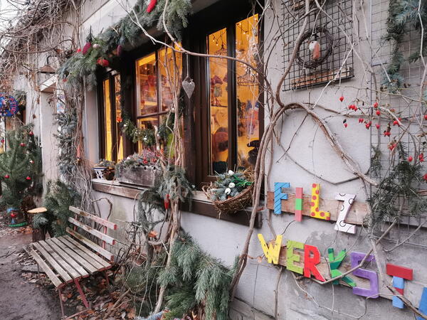 Bild vergrößern: Zu sehen ist ein weihnachtlich geschmücktes Fenster der Weberhäuser mit Blick in die Filzwerkstatt.