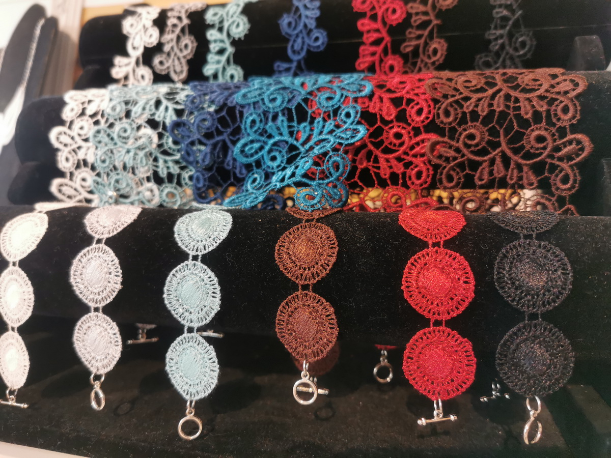 Bild vergrößern: Unterschiedlich farbige Schmuckstücke aus verschiedenen Plauener Spitzen werden präsentiert.