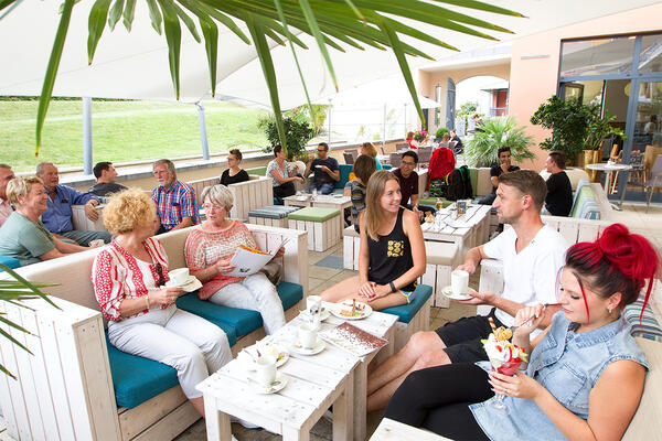 Bild vergrößern: Gäste sitzen im Außenbereich des Kaffeehaus Müller