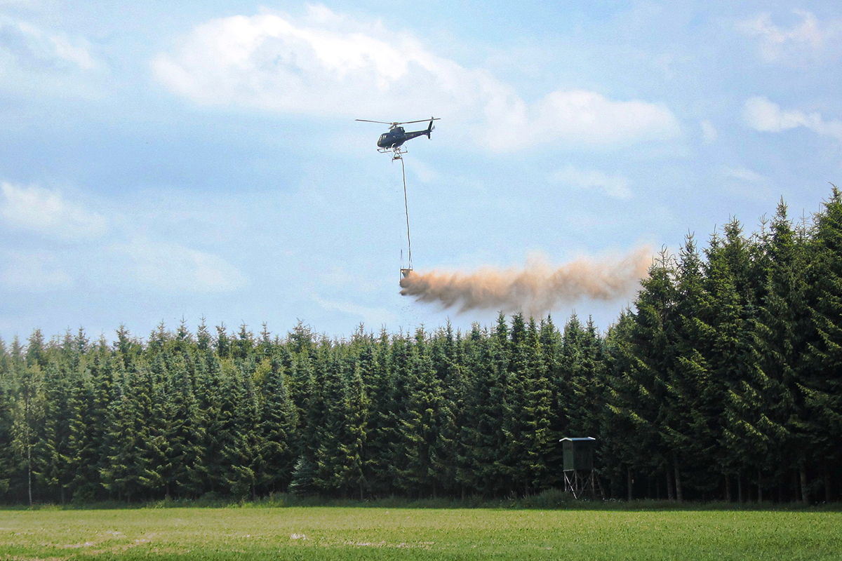 Bild vergrößern: Hubschrauber bringen Kalk in den Wäldern aus