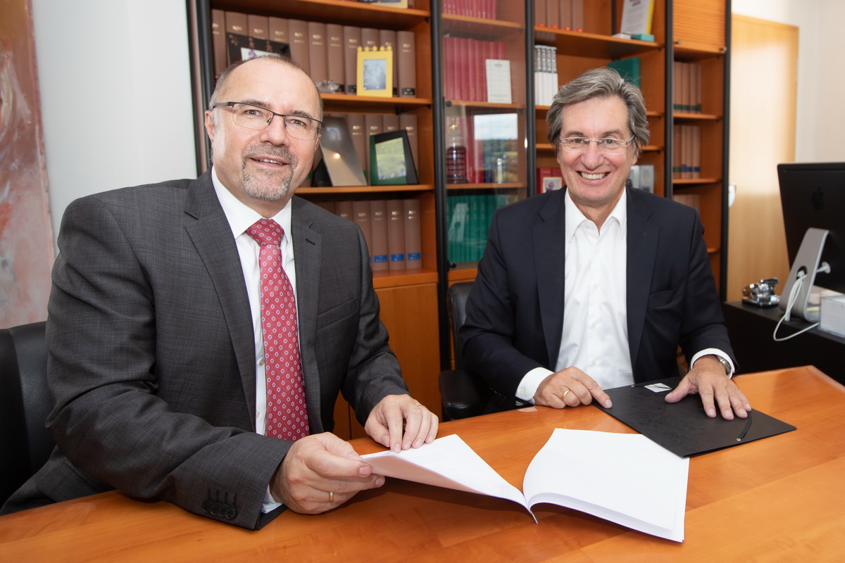 Bild vergrößern: Oberbürgermeister Steffen Zenner (links) und Rainer Gläß, Gründer und CEO der GK Software SE,  beim Unterzeichnen des Kaufvertrags beim Notar.